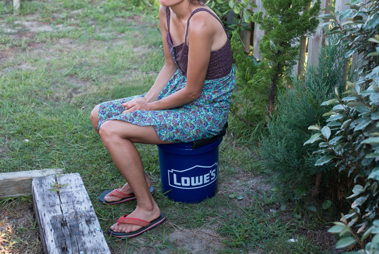 woman sitting on a DIY camper van toilet.